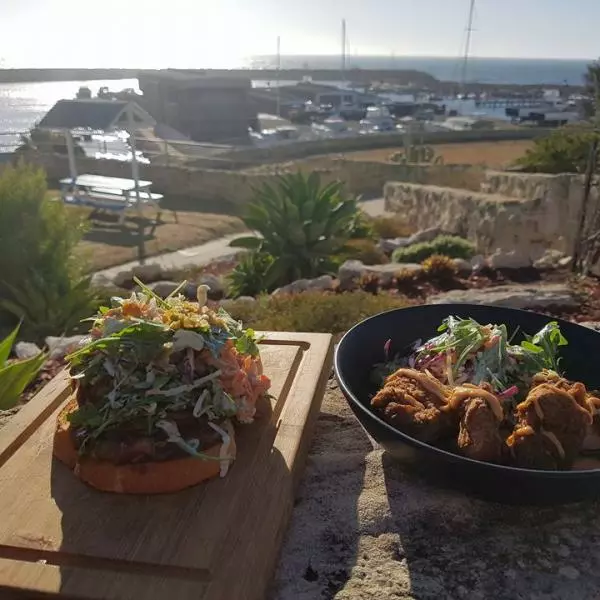 A plate of food and a sandwich on a table with a marina view at Atlantis Beach.