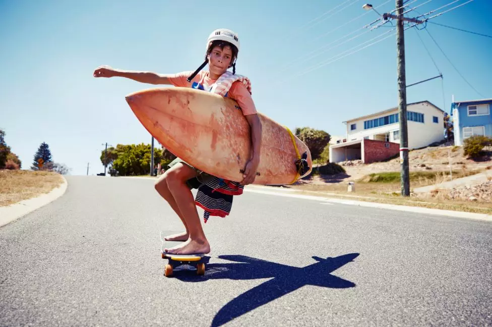 A Man Skateboarding Down A Street At Atlantis Beach, Showcasing His Skills And Enjoying The Ride.
