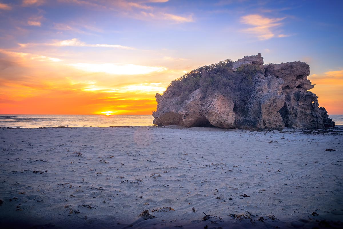 A stunning rock formation on Atlantis Beach at sunset, showcasing nature's beauty and tranquility.