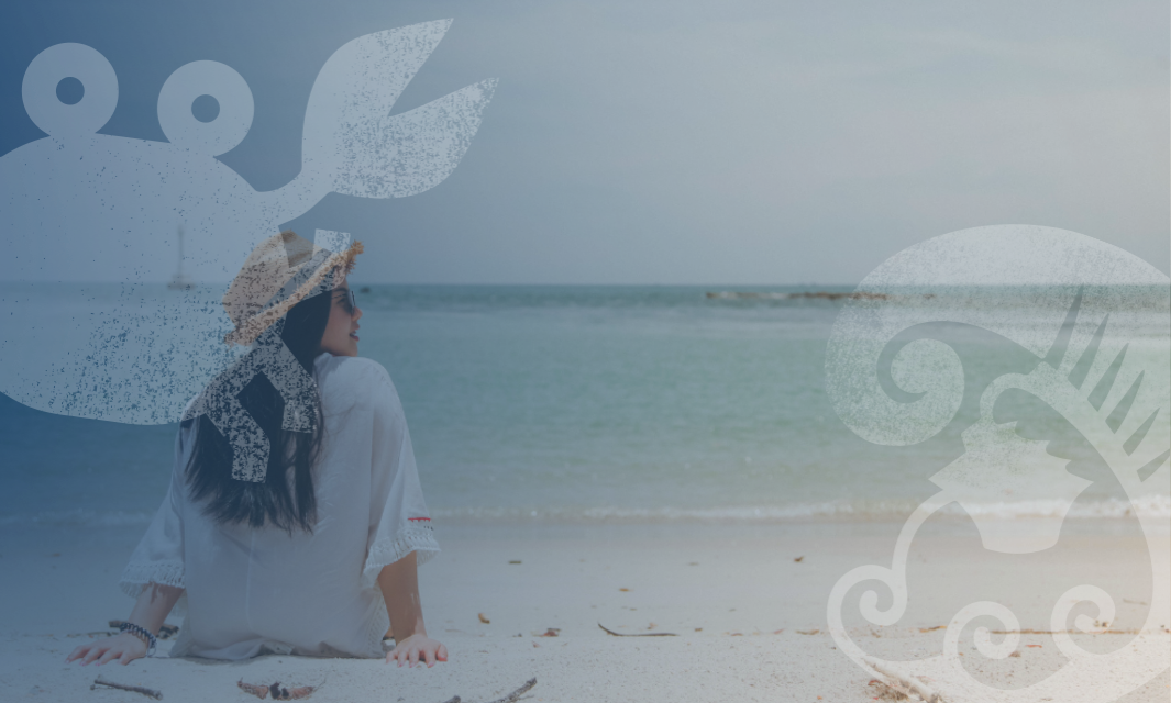 A woman sitting on the beach, moving to the beach, with a crab and fish illustrations, at Two Rocks, Atlantis.