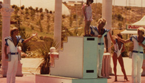 A group of people standing on a stage with a man on a podium at Atlantis Beach.