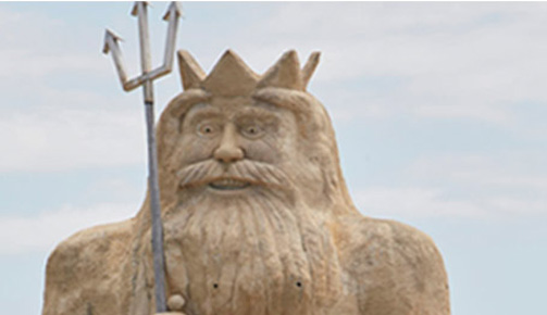 Statue of man with crown and spear at Atlantis Beach.
