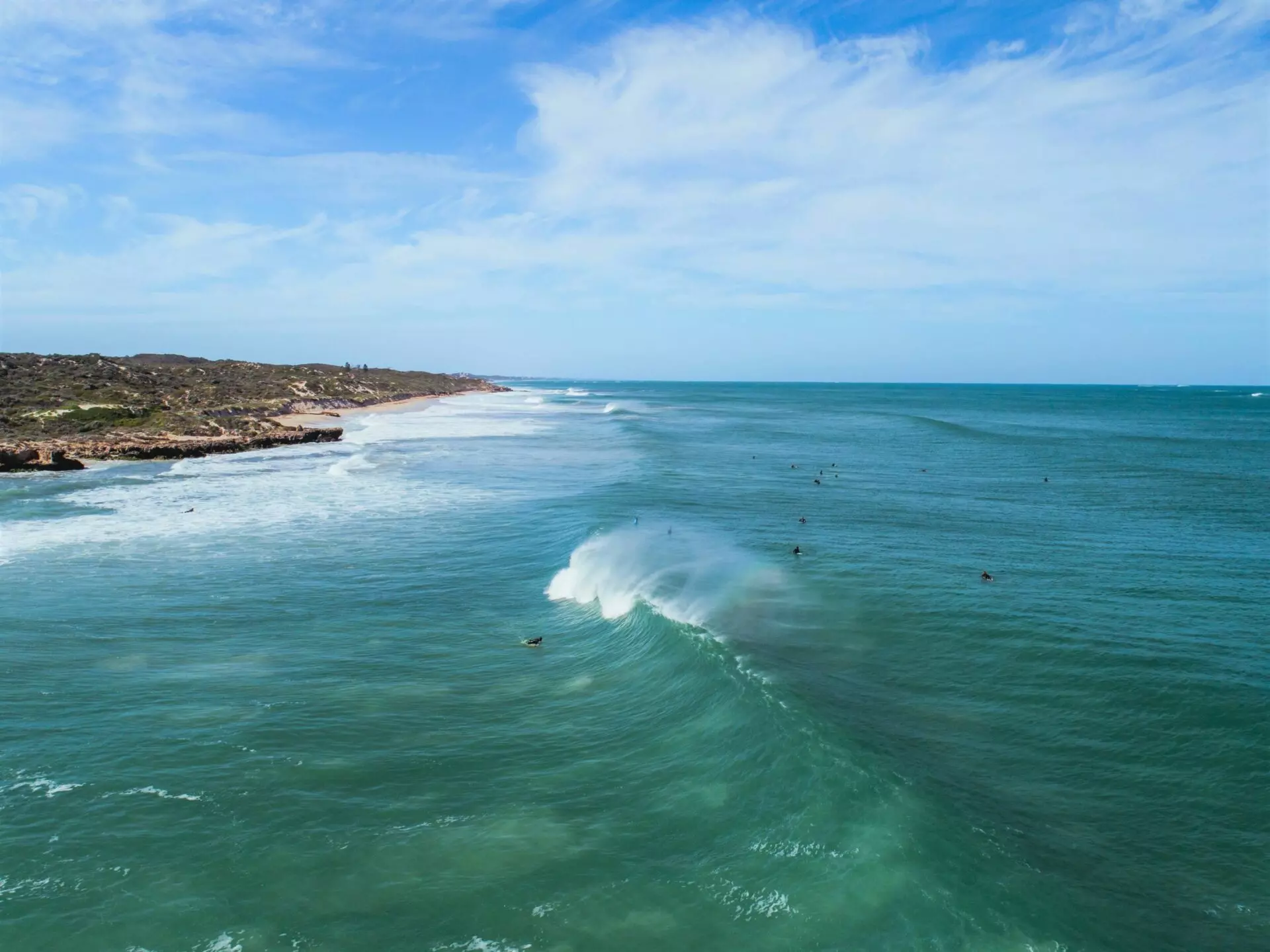 A scenic coastal view with surfers in the water, showcasing the Two Rocks property outlook